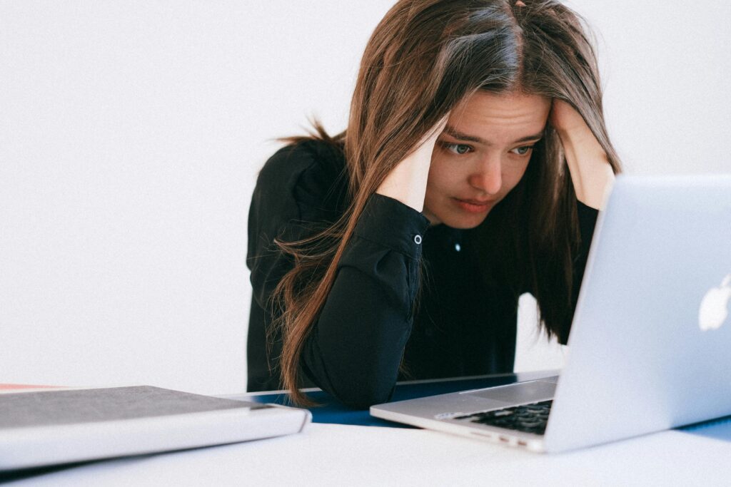 A woman at her computer feeling burned out.