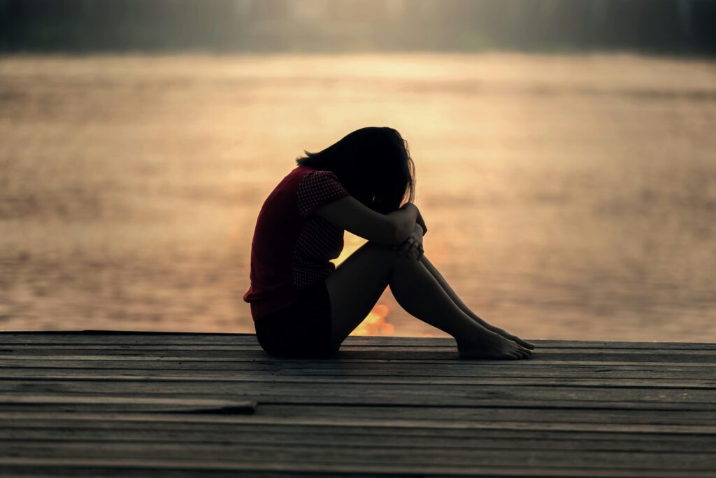 A girl with her head down on the dock
