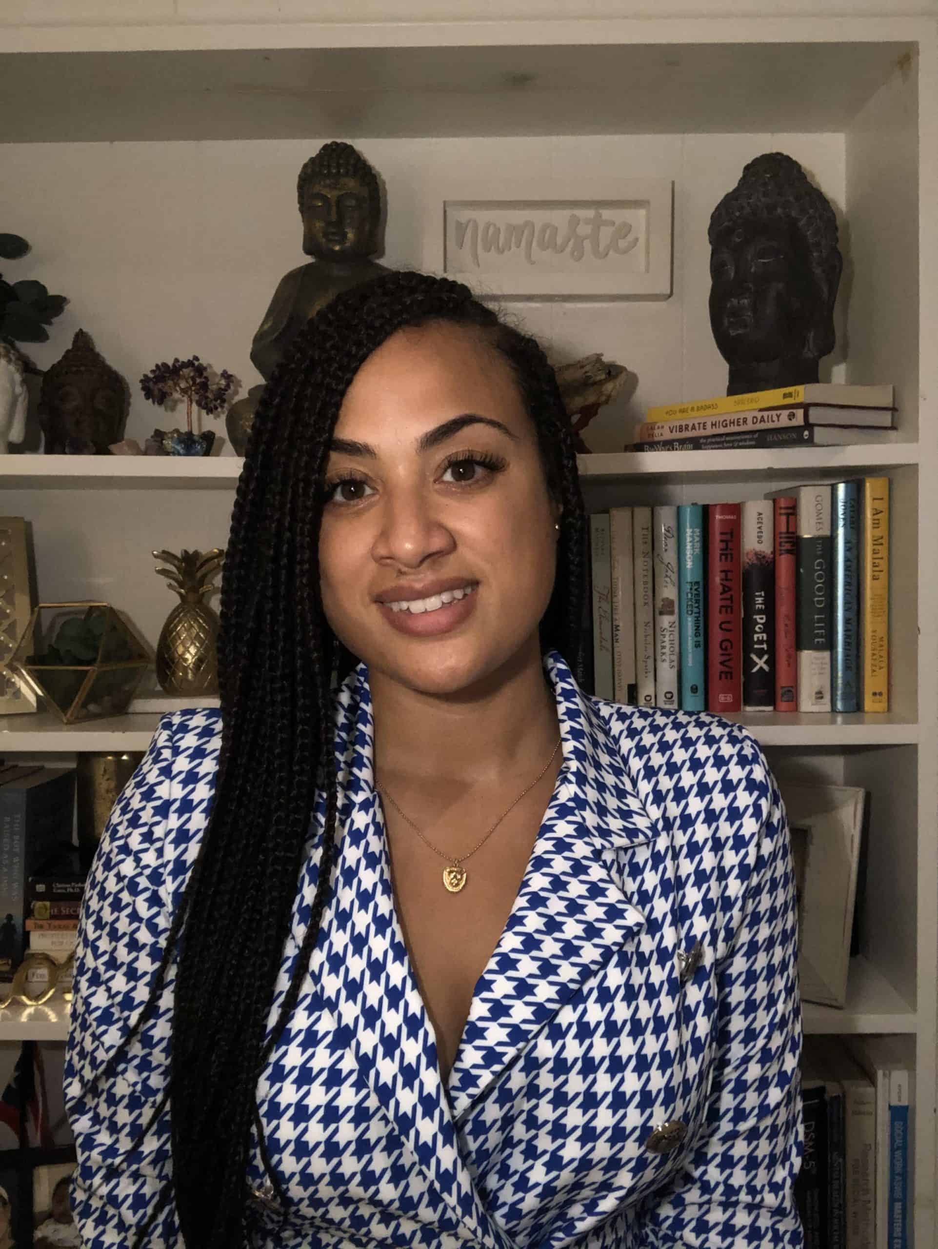 Smiling woman with braided hair standing in front of bookshelves